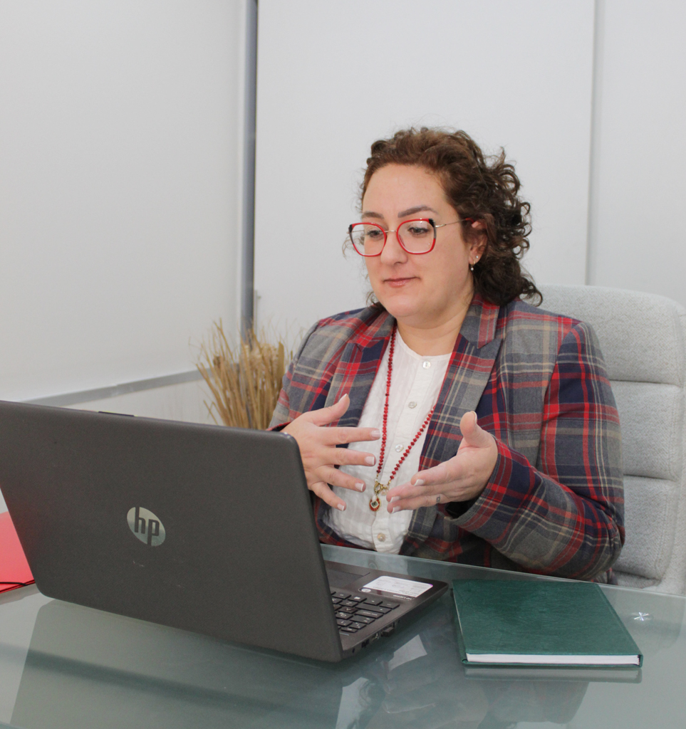 Escribana Eliana Frías trabajando con su notebook en el despacho